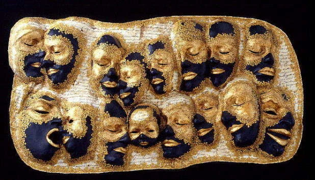 Panel of gold and black papier-mâché faces