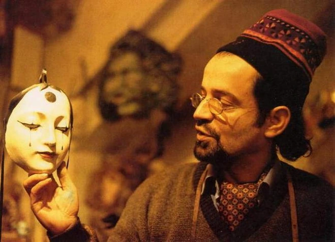 Agostino Dessì holding a white mask in the atelier
